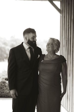 Black and white portrait of wedding party members sharing a candid moment.
