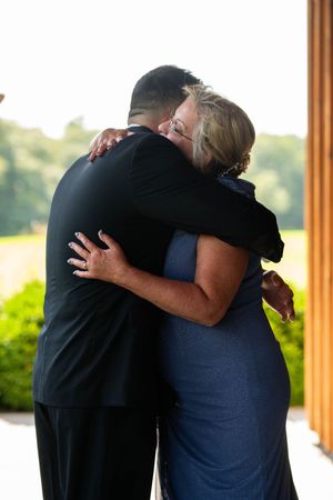 Two people share an emotional embrace during what appears to be a wedding ceremony.