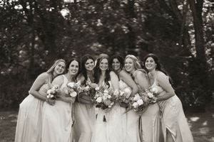 Wedding party laughing together in a candid black and white photo.