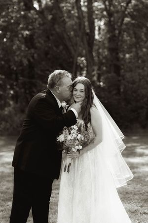Black and white wedding portrait capturing an intimate moment between a bride and companion.