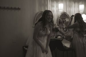 An intimate getting-ready moment captured in black and white during wedding preparations.
