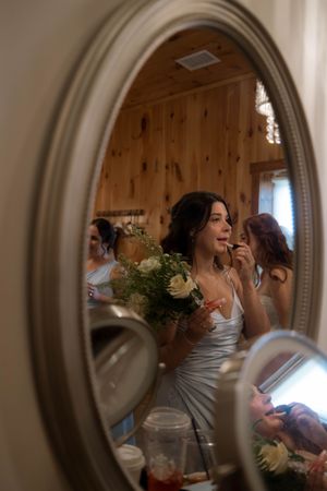 A mirror reflection shows wedding preparation moments with elegant decor and flowers.