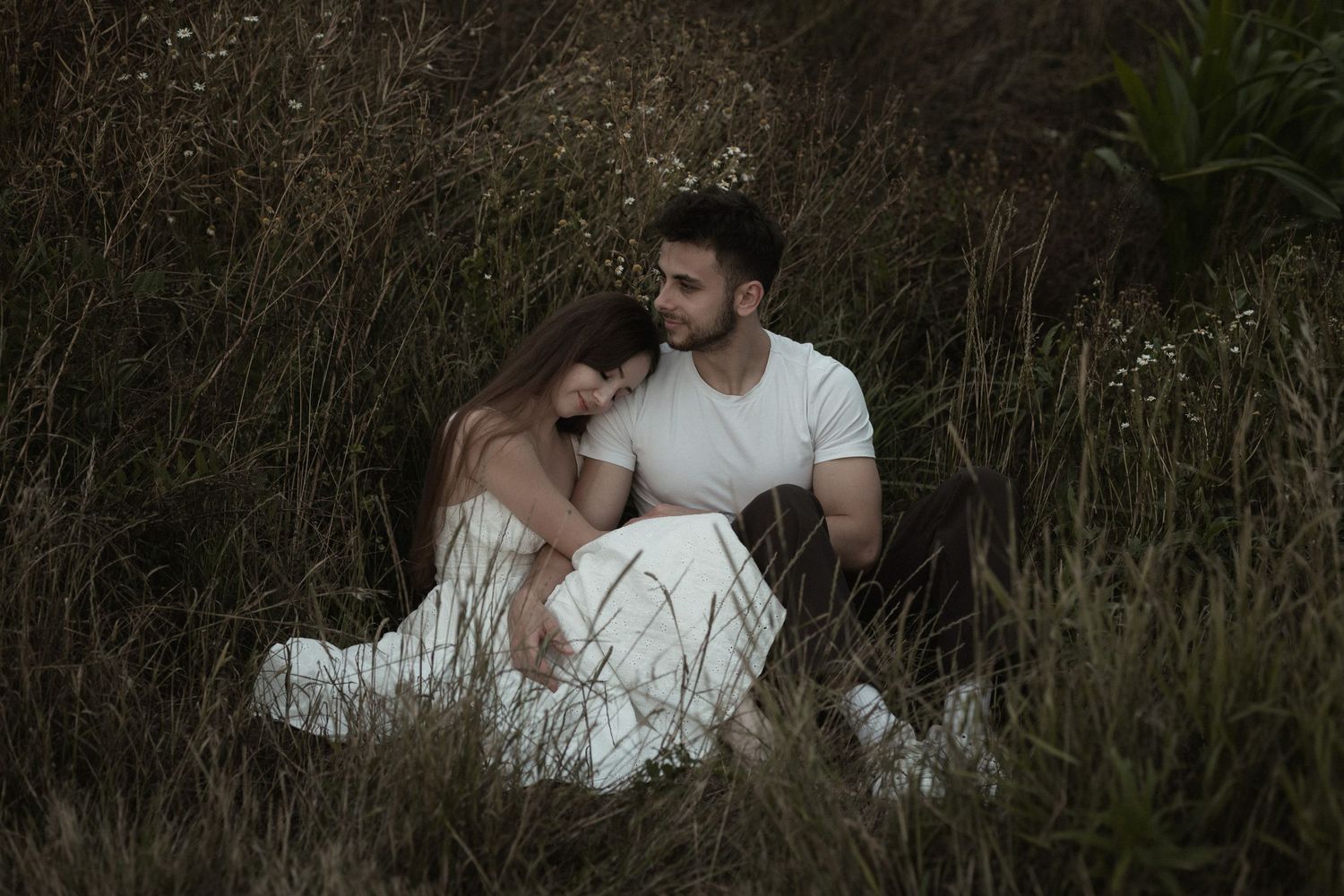 A series of seven intimate photos showing a romantic couple embracing outdoors in a natural setting with tall grass and foliage.
