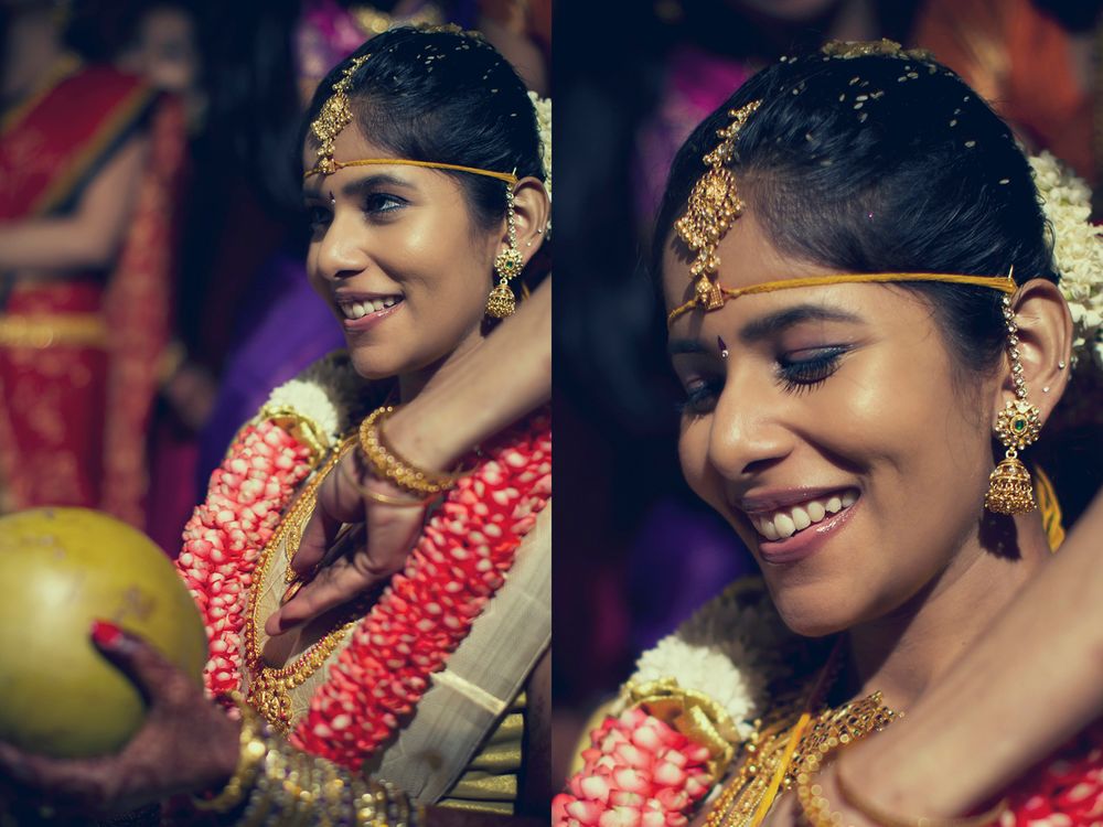 Traditional South Indian bride wearing red garlands and gold jewelry holds a coconut during wedding ceremony rituals.