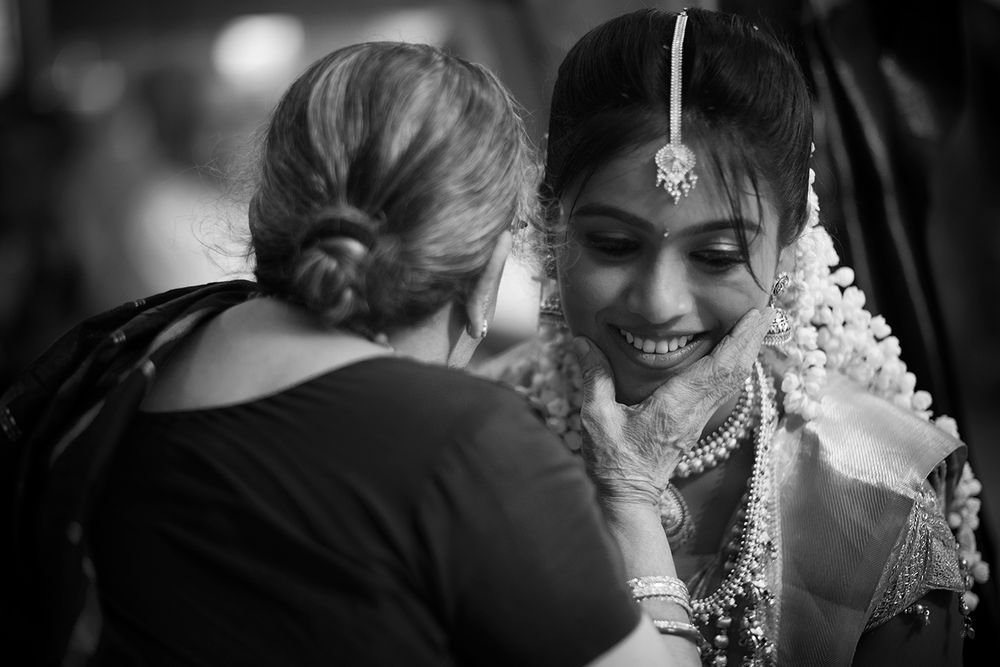 Black and white collage of candid moments showing emotional embraces and joyful expressions at a wedding celebration.