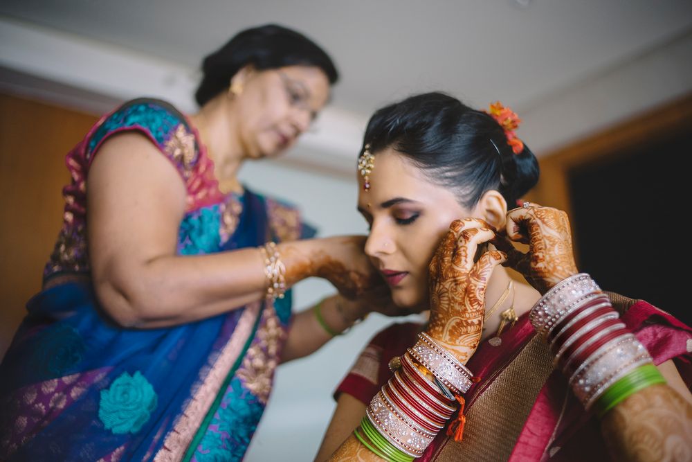 A bride gets ready for her traditional Indian wedding ceremony, adorned with colorful jewelry and henna designs.