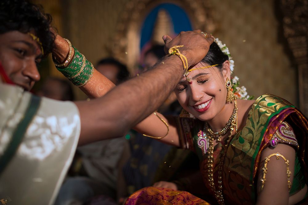 Traditional Indian wedding ceremony shows application of sindoor during a sacred ritual moment.