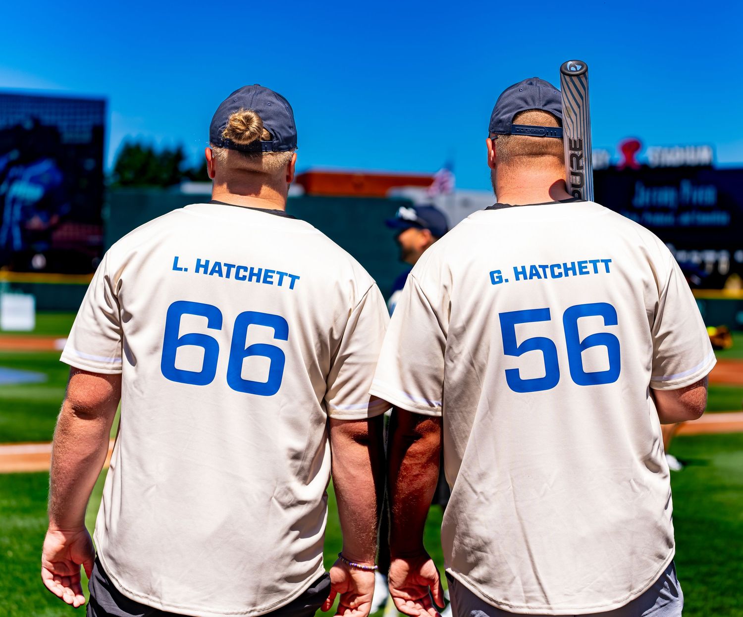 Two men wearing matching baseball jerseys numbered 66 and 56 with the name Hatchett on the back.