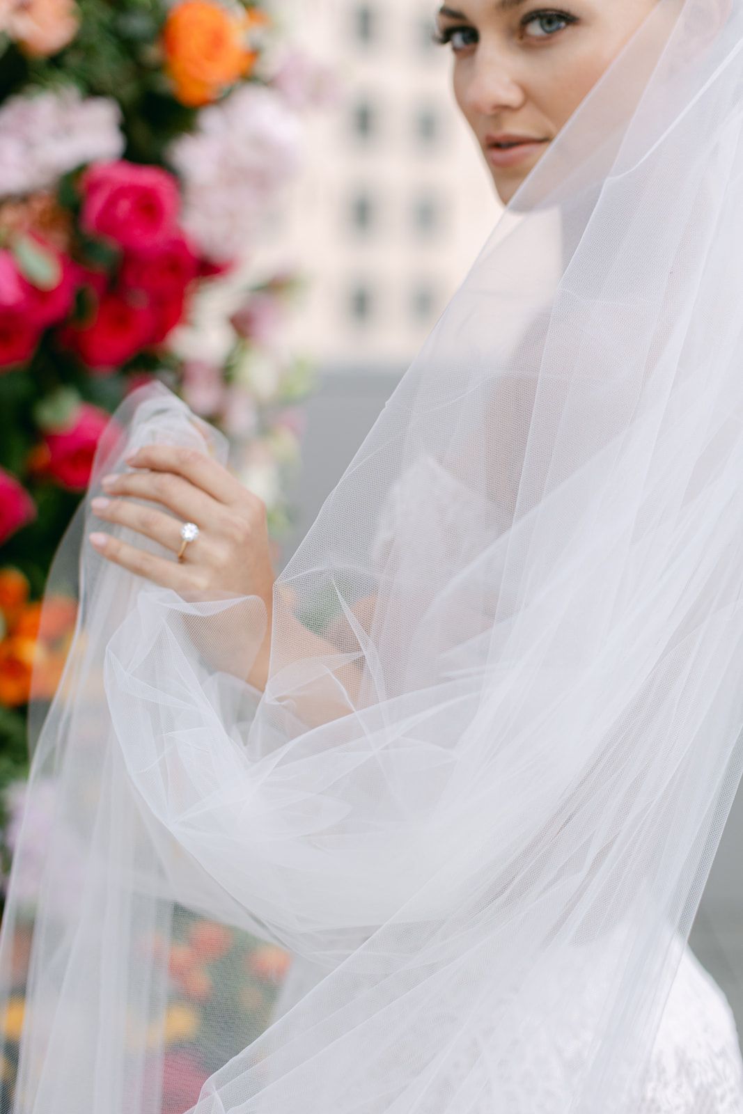 Wedding bride with veil and romantic floral decor at her outdoor ceremony.