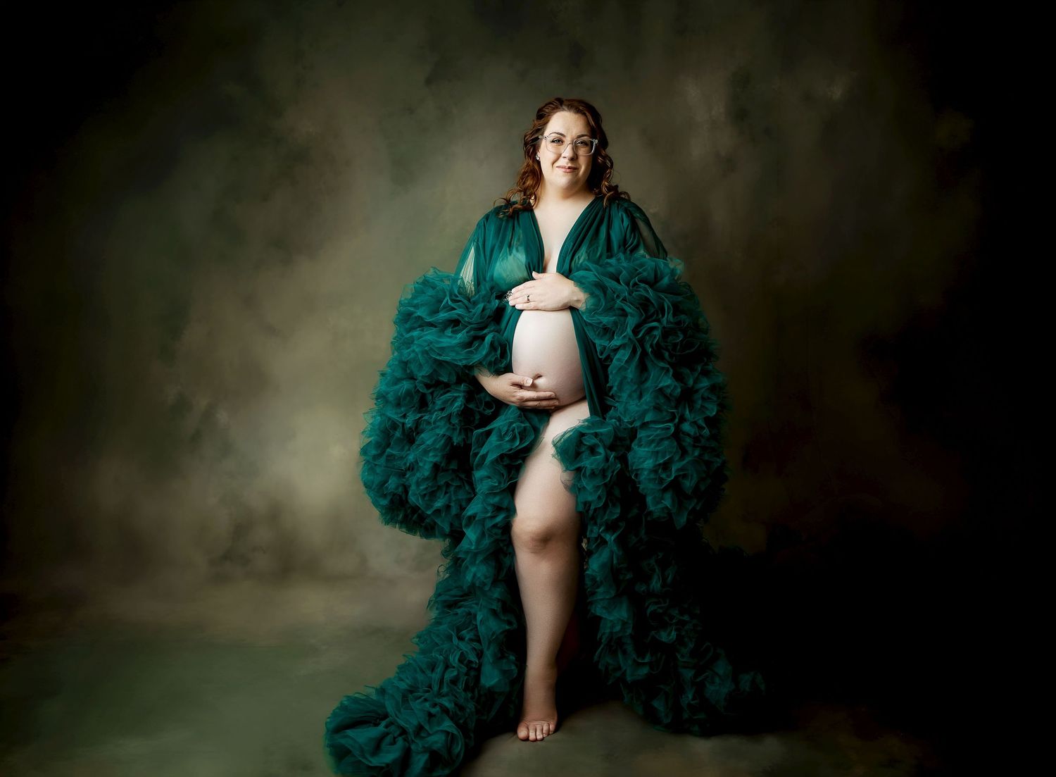 Elegant emerald green tulle gown with sweetheart neckline and flowing long sleeves displayed on a mannequin.