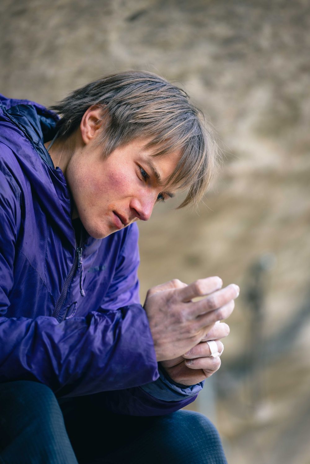 Alex Megos taping his fingers in Buoux, France. Photo Jan Virt.