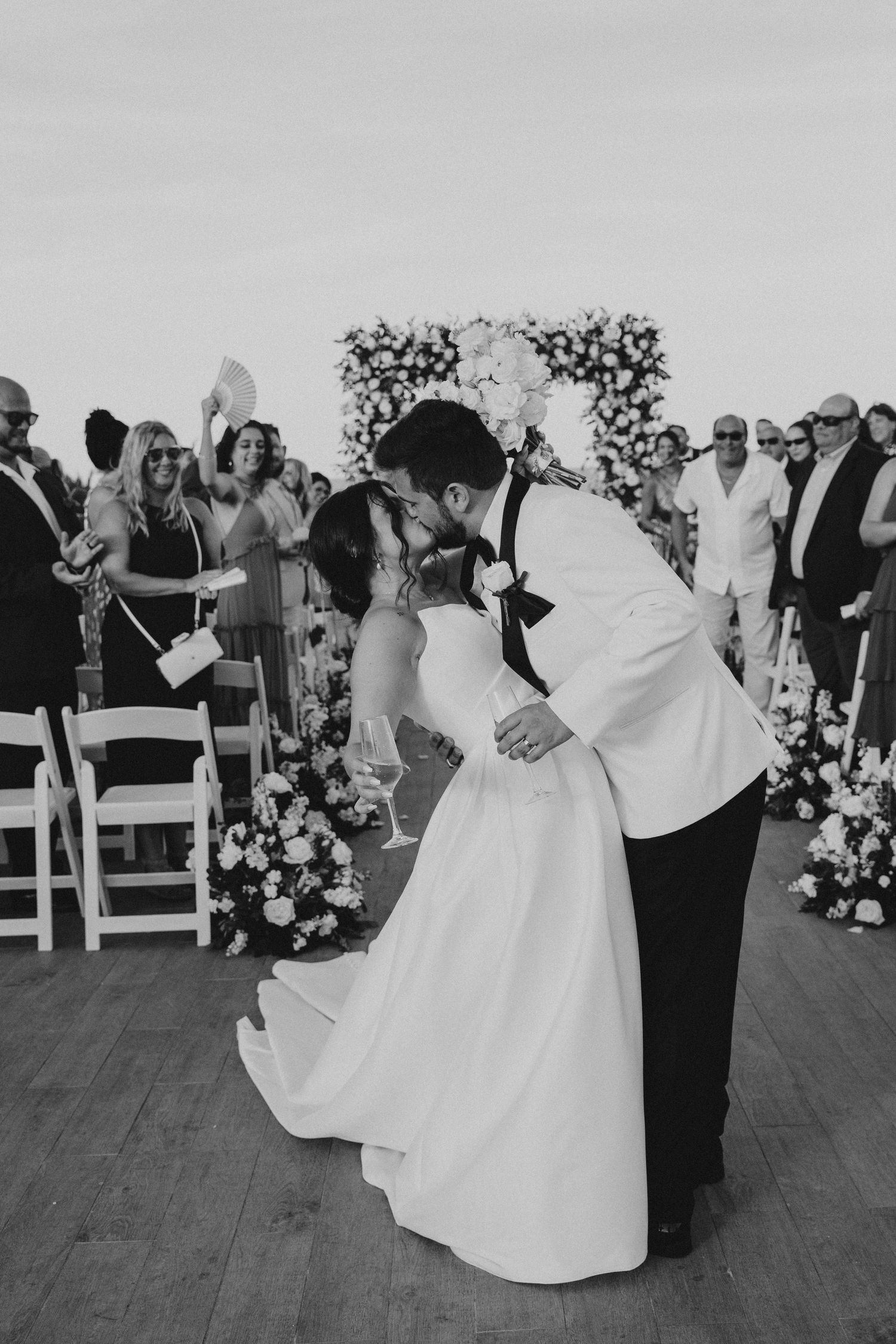 Elegant black and white photo of a couple's first dance at their outdoor wedding reception.