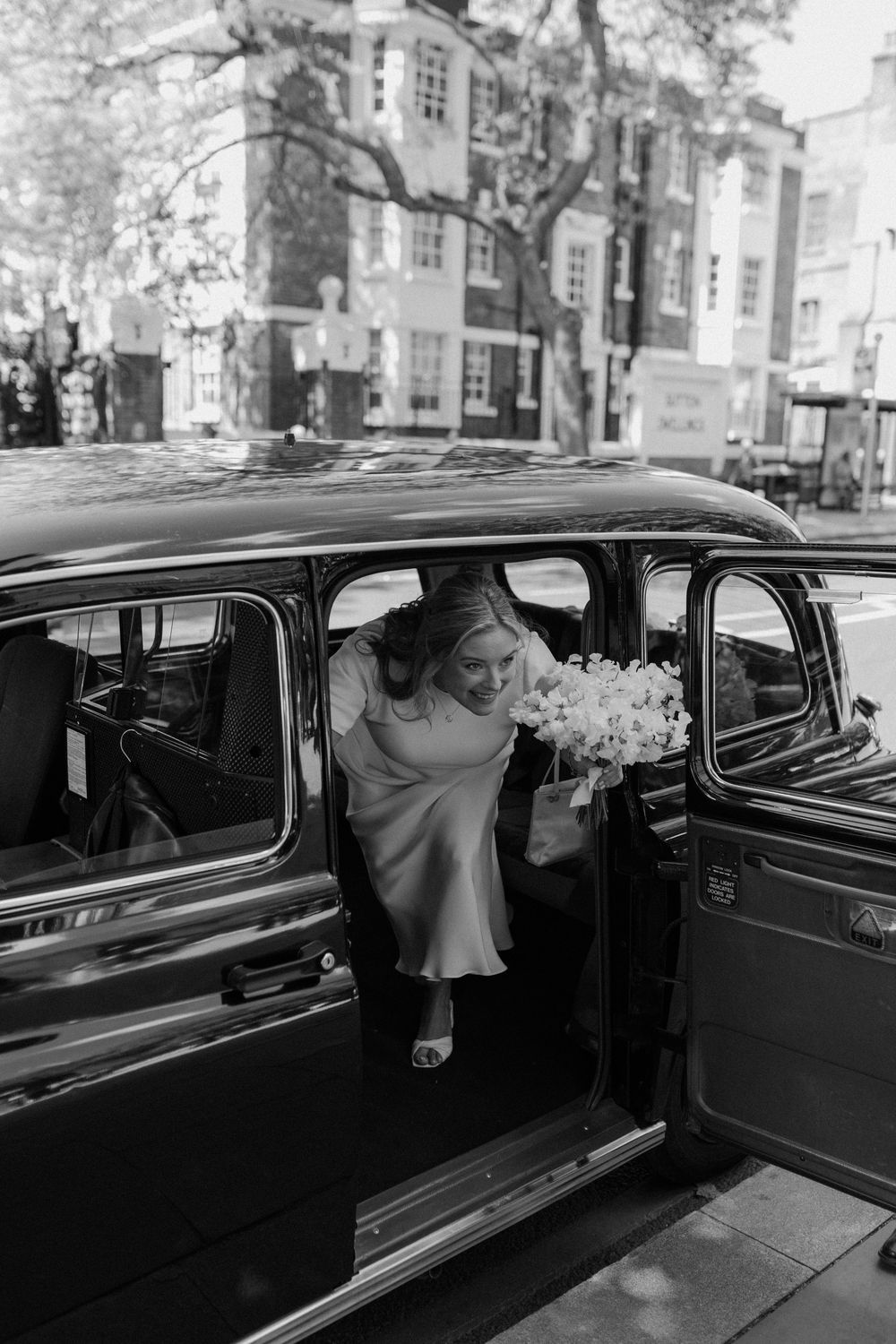 Bride arrives in London cab at her Islington Town Hall London wedding.
