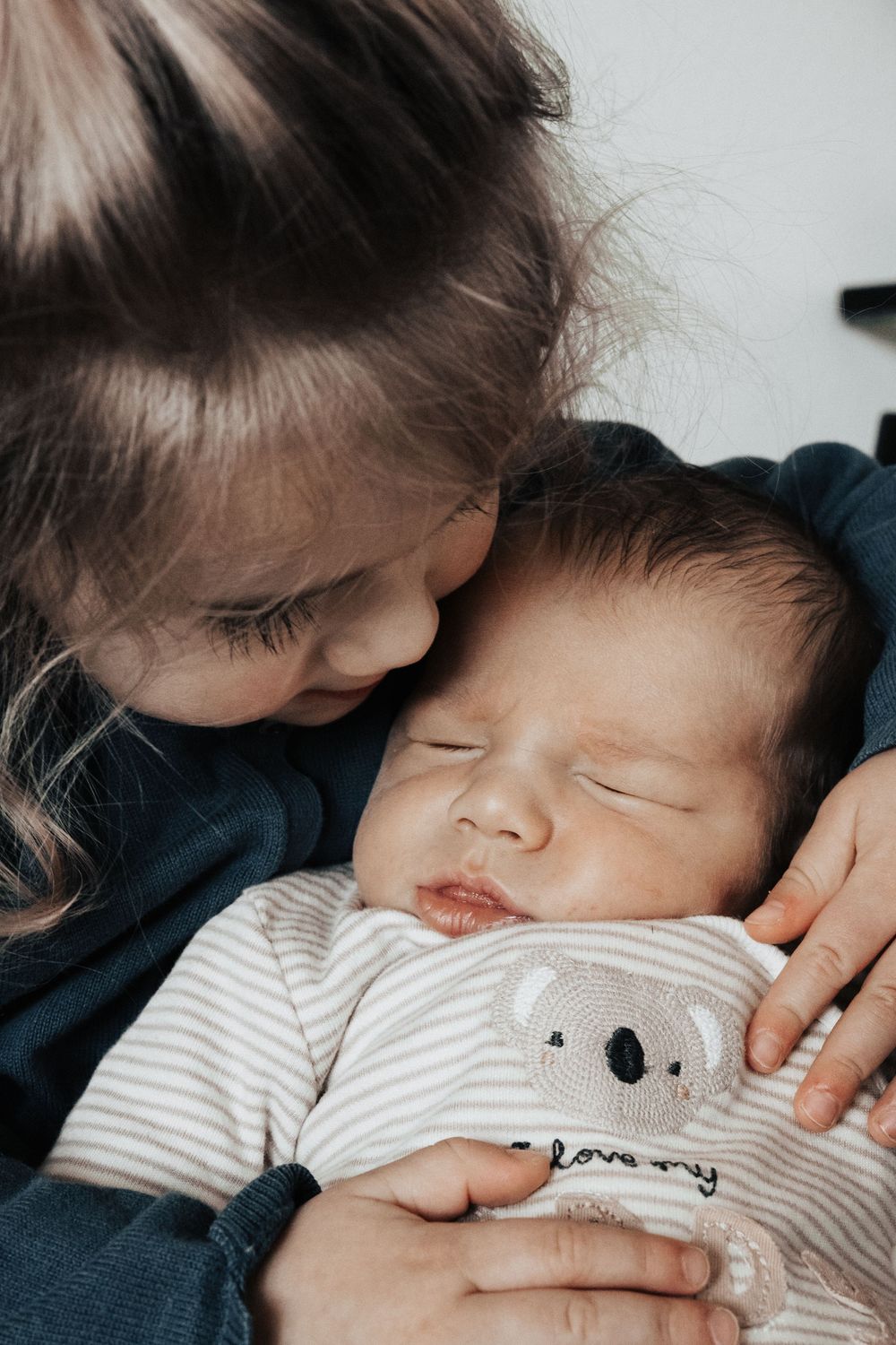 Grosse Schwester hält kleinen Bruder