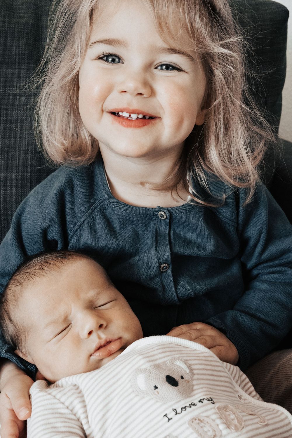 Grosse Schwester hält kleinen Bruder