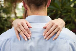 Close-up view of hands resting on shoulders in light blue fabric.