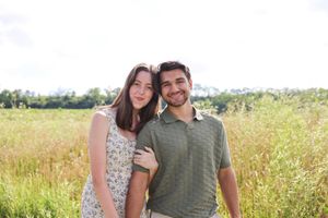 Couple sharing tender moments in a sunlit wildflower meadow.