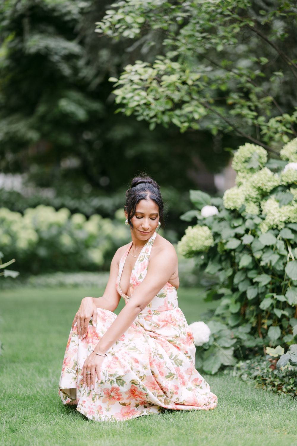 A dreamy garden scene showcases a floral dress against blooming hydrangeas and lush greenery on a summer day.