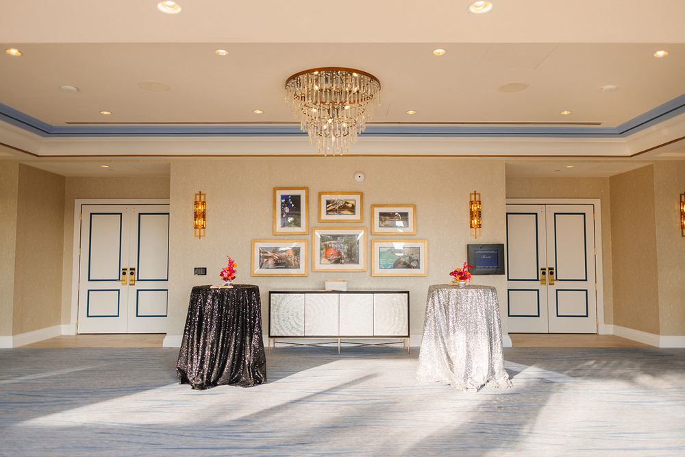 Large hotel conference room with elegant chandeliers and classic white wall paneling.