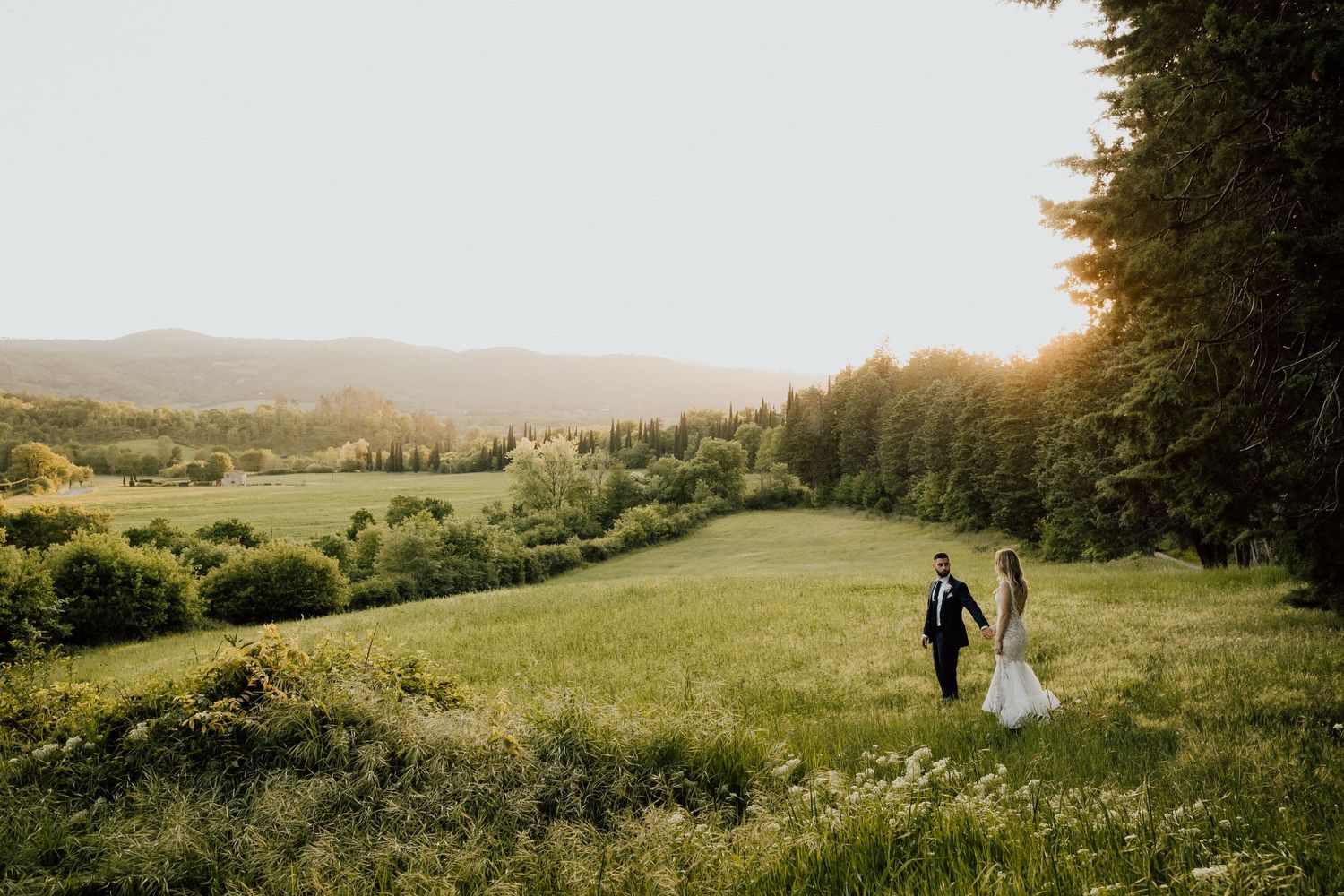 Romantic couple walking through Italian countryside | Bride & Groom Candid Moment | Bucine, Italy Wedding | Destination Photographer