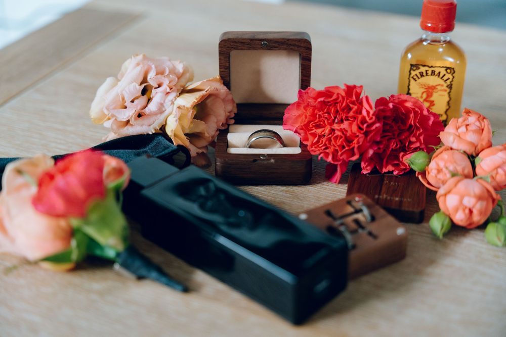 Wedding details including rings, flowers and champagne arranged on a table.