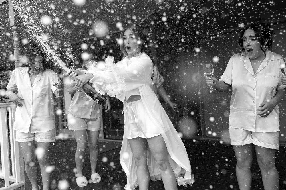Black and white photo of celebratory moment with champagne spray.