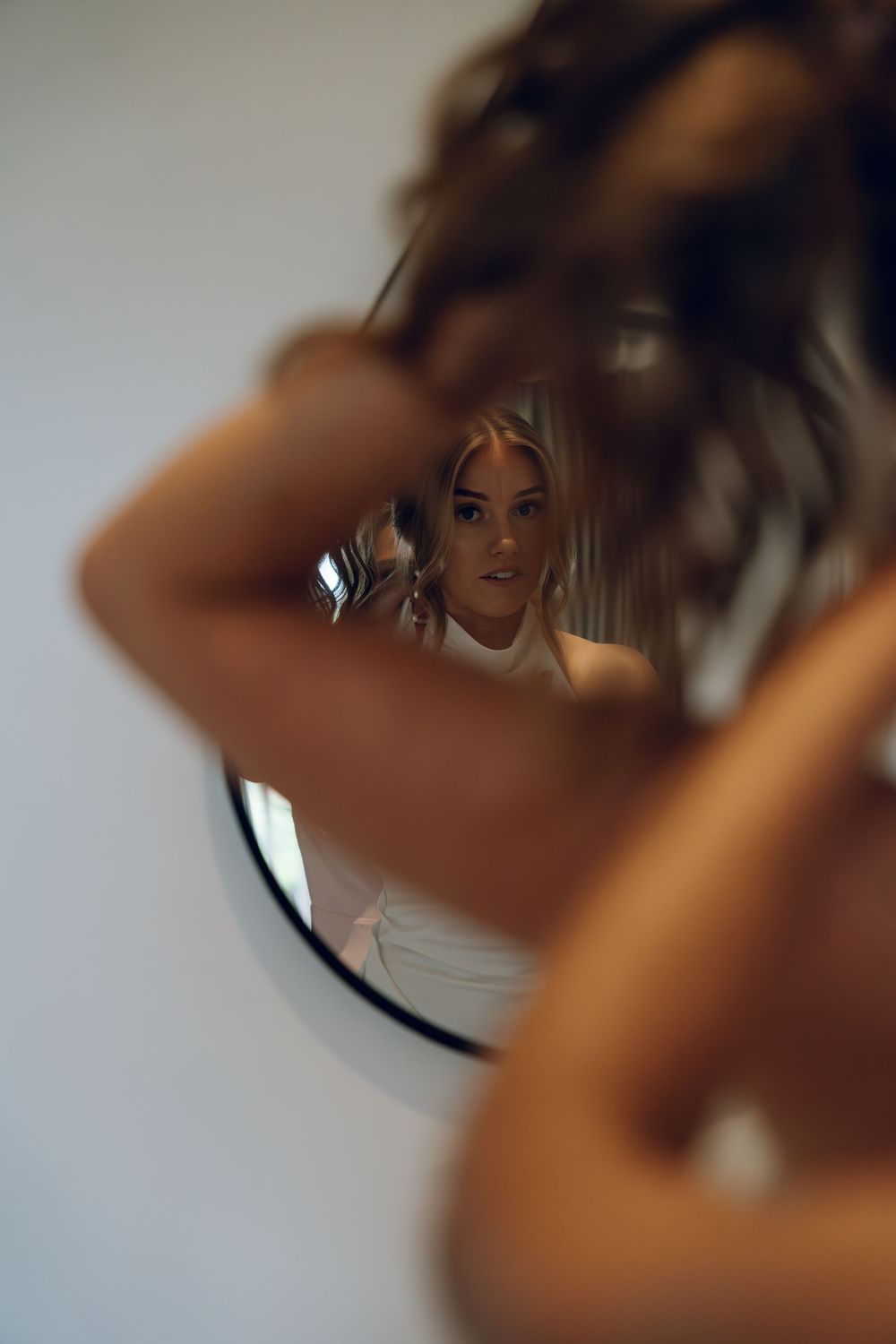 Artistic mirror reflection shot of bridal beauty preparations.