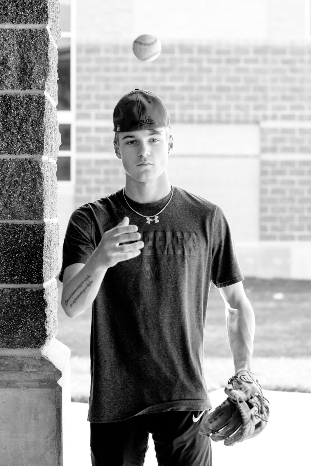 Black and white sequence of athlete in baseball cap throwing pitches from multiple angles.