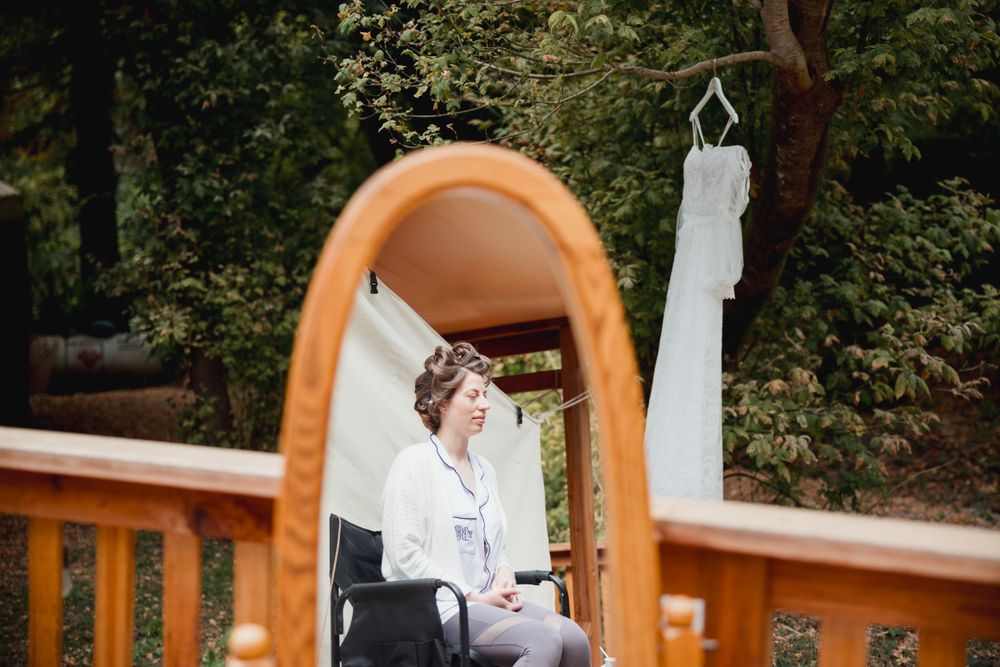 Wedding preparation reflected in vintage mirror on outdoor wooden deck.