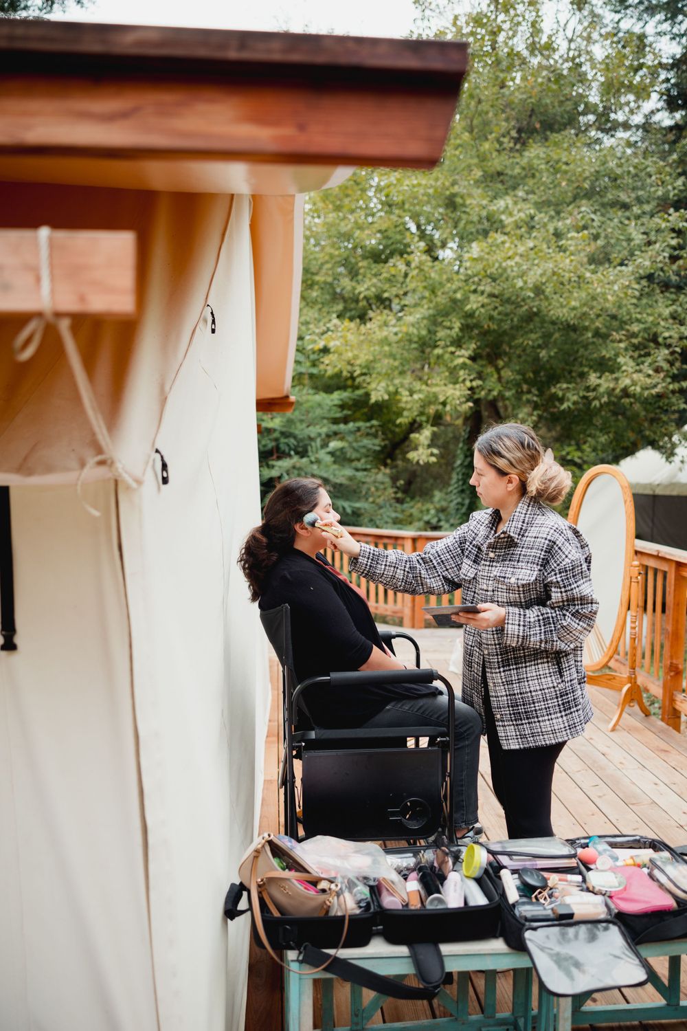 Wedding preparation scene with makeup and styling taking place on outdoor deck.