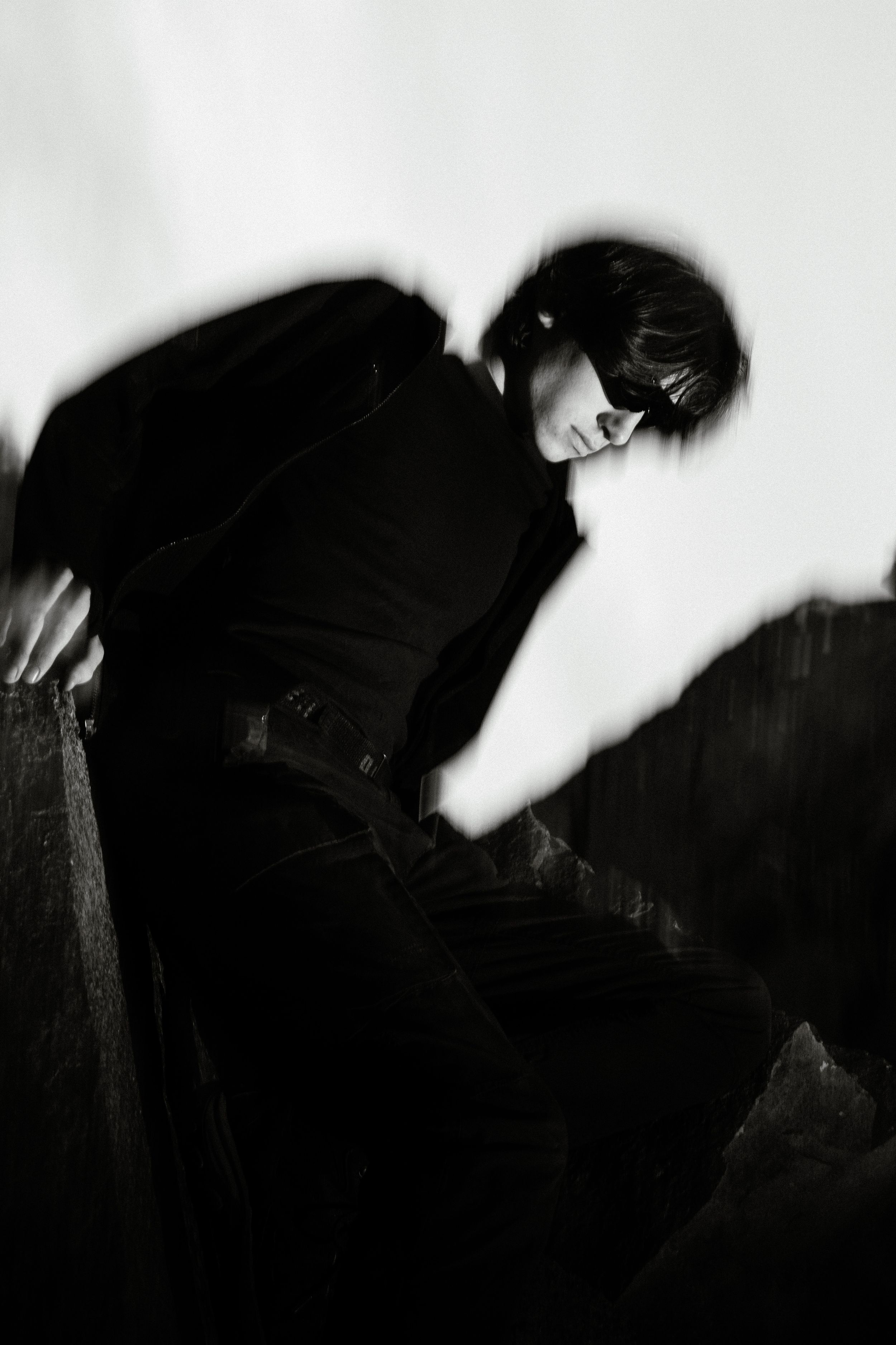 High contrast black and white fashion portrait with artistic motion blur effect.