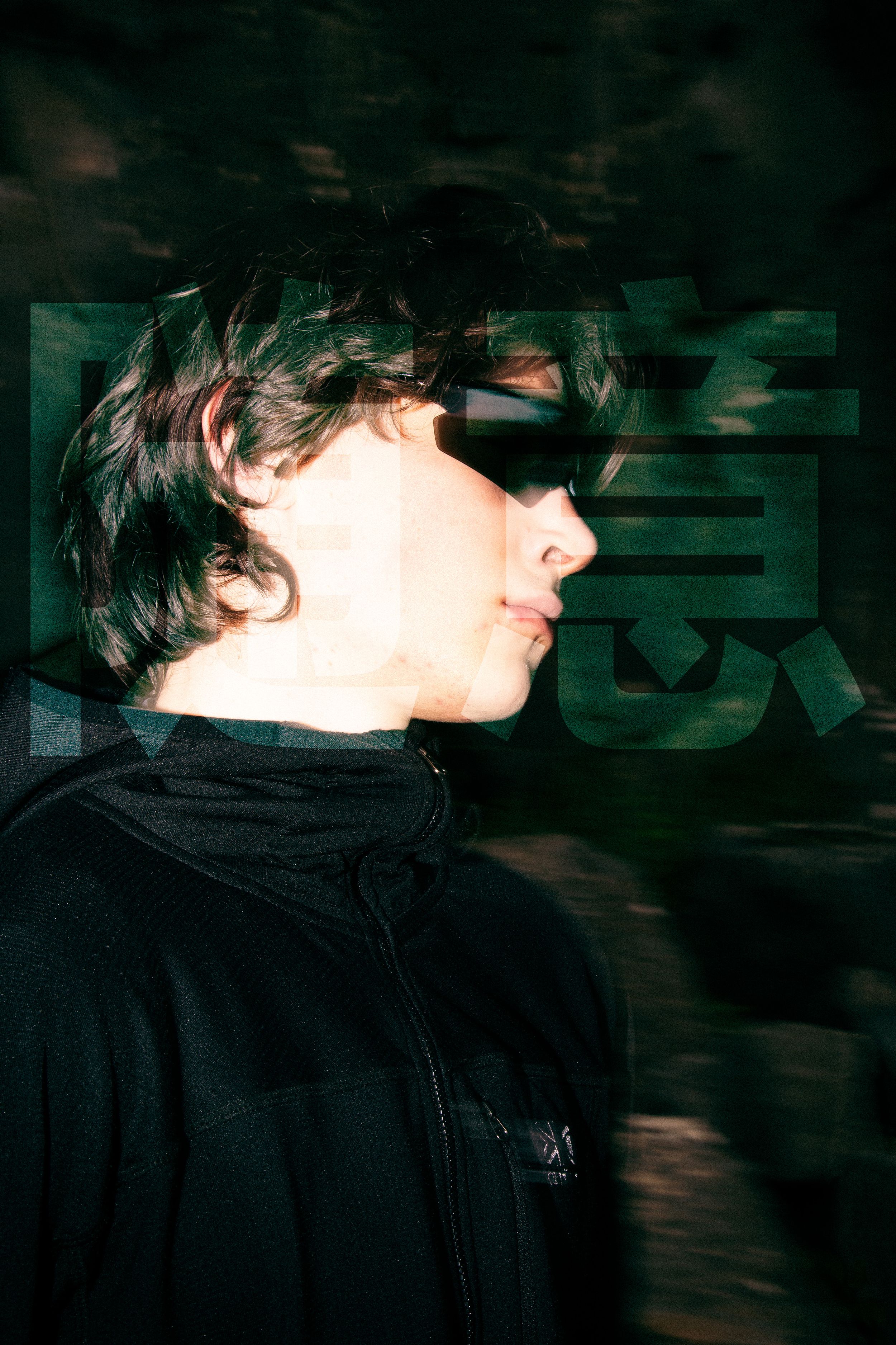 Profile view of person in black jacket against dark background with motion blur.
