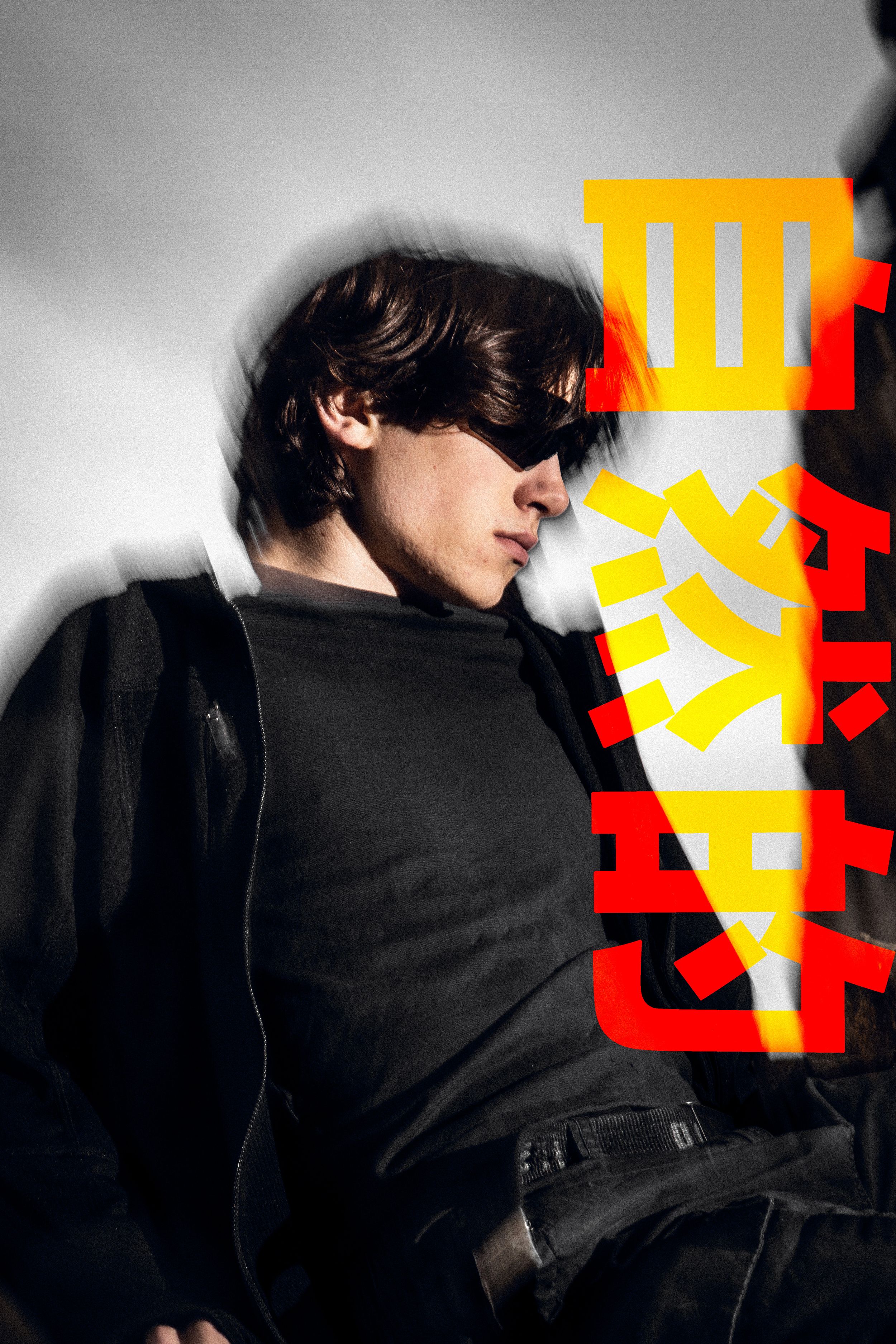Person in dark clothing against wall with bright yellow and red graphic elements.