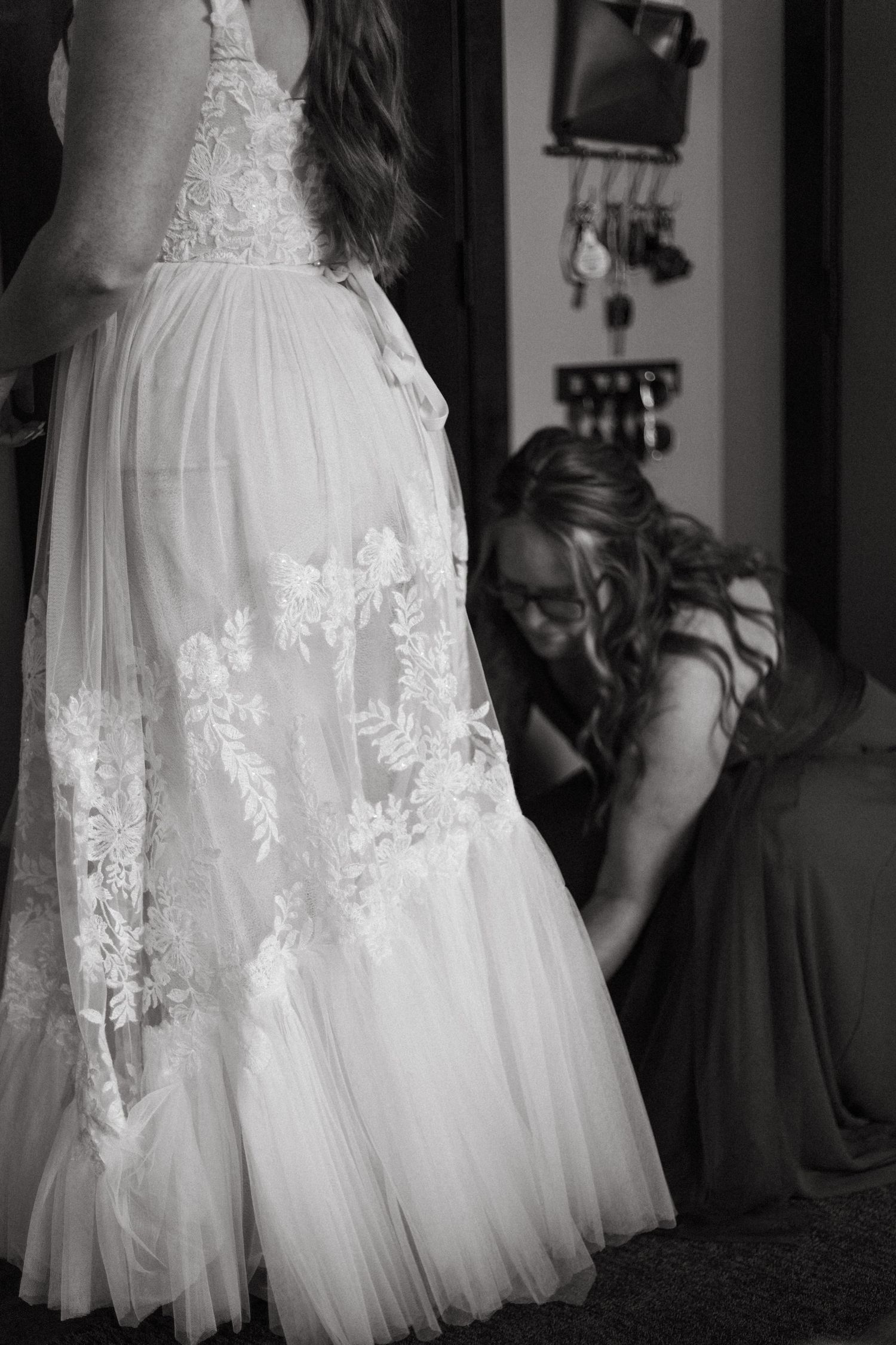 Black and white photo showing the detailed lace and tulle of a wedding dress.