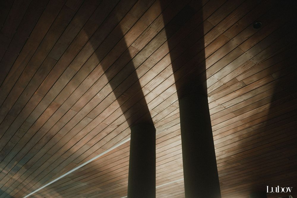 Architectural detail showing wooden ceiling panels with dramatic shadows and light patterns.