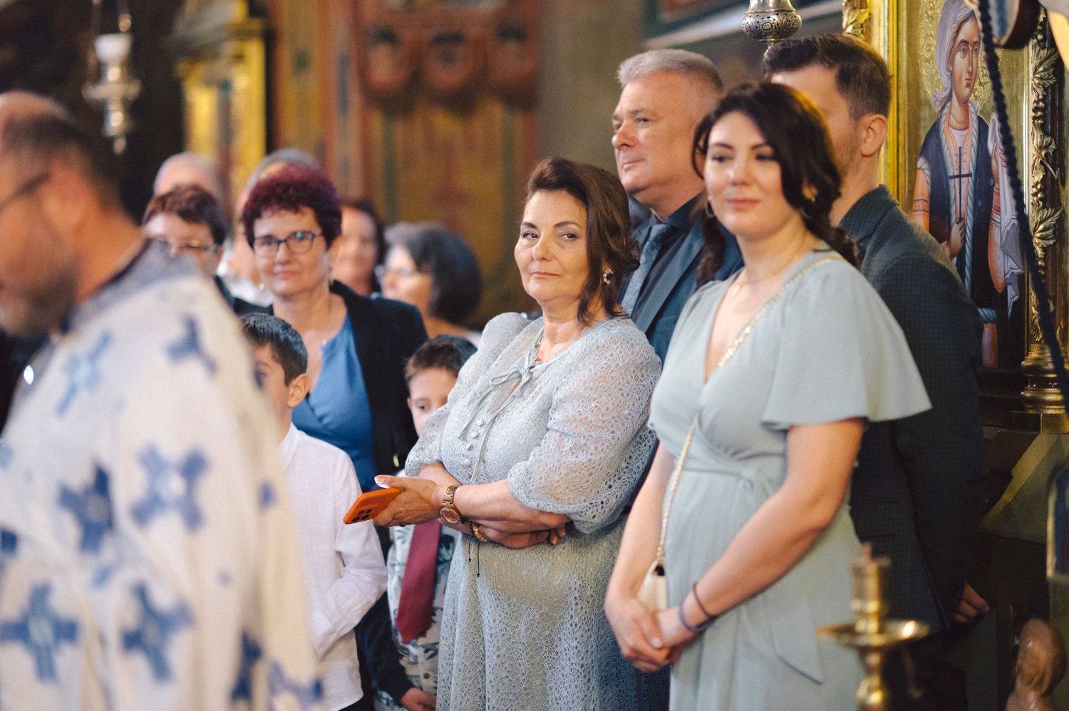 Orthodox church service attendees stand together during a traditional religious ceremony.