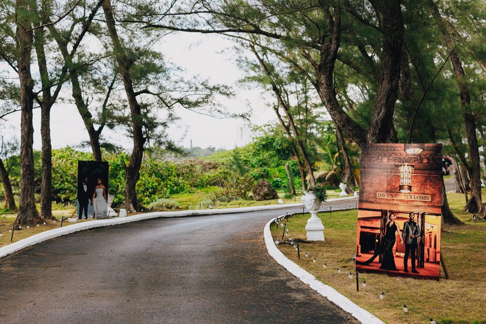 A tree-lined walking path with red benches along a scenic coastal park area.