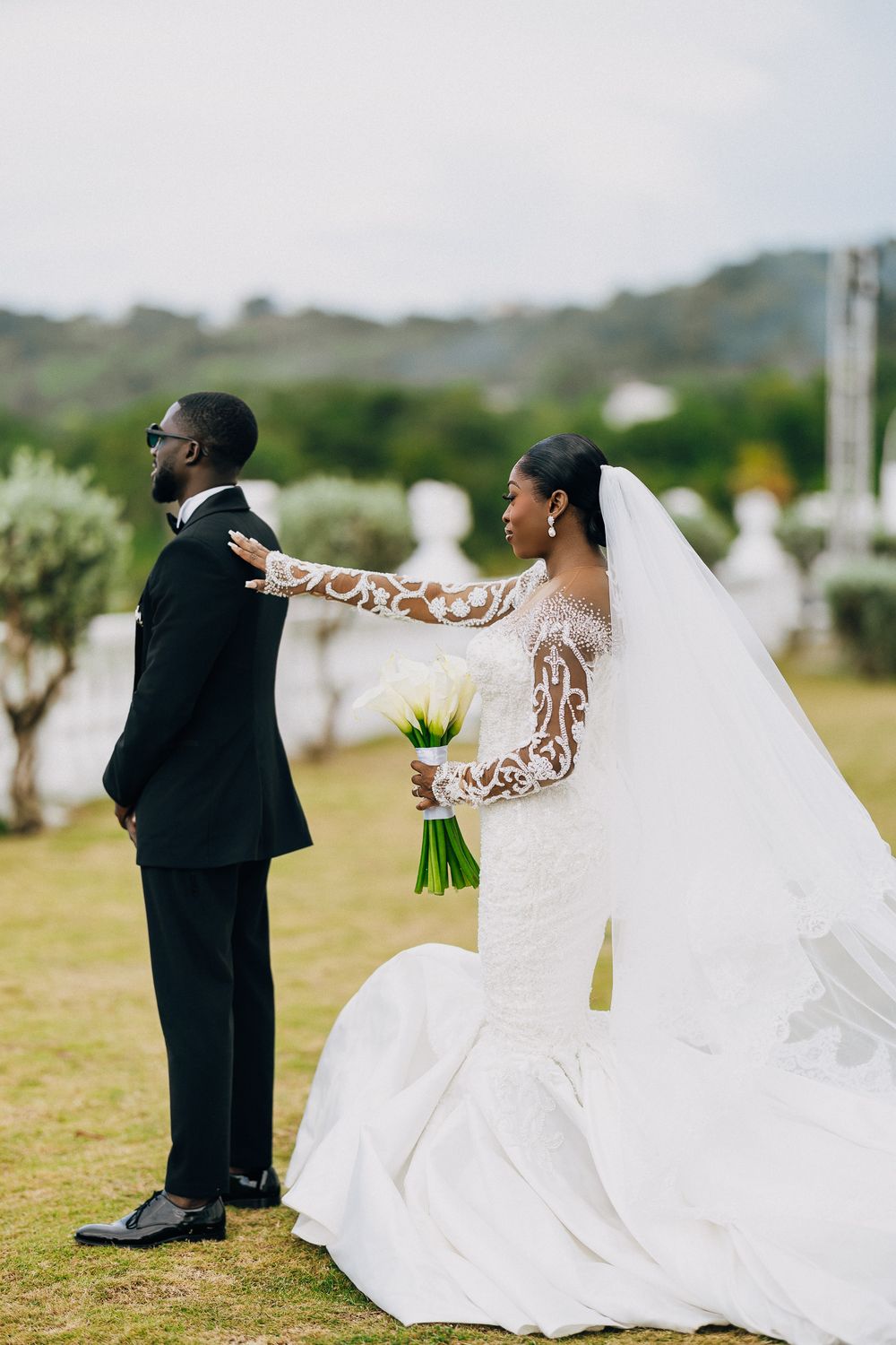 A creative wedding photo sequence showing a couple playfully posing in a grassy field with mountains in the background.