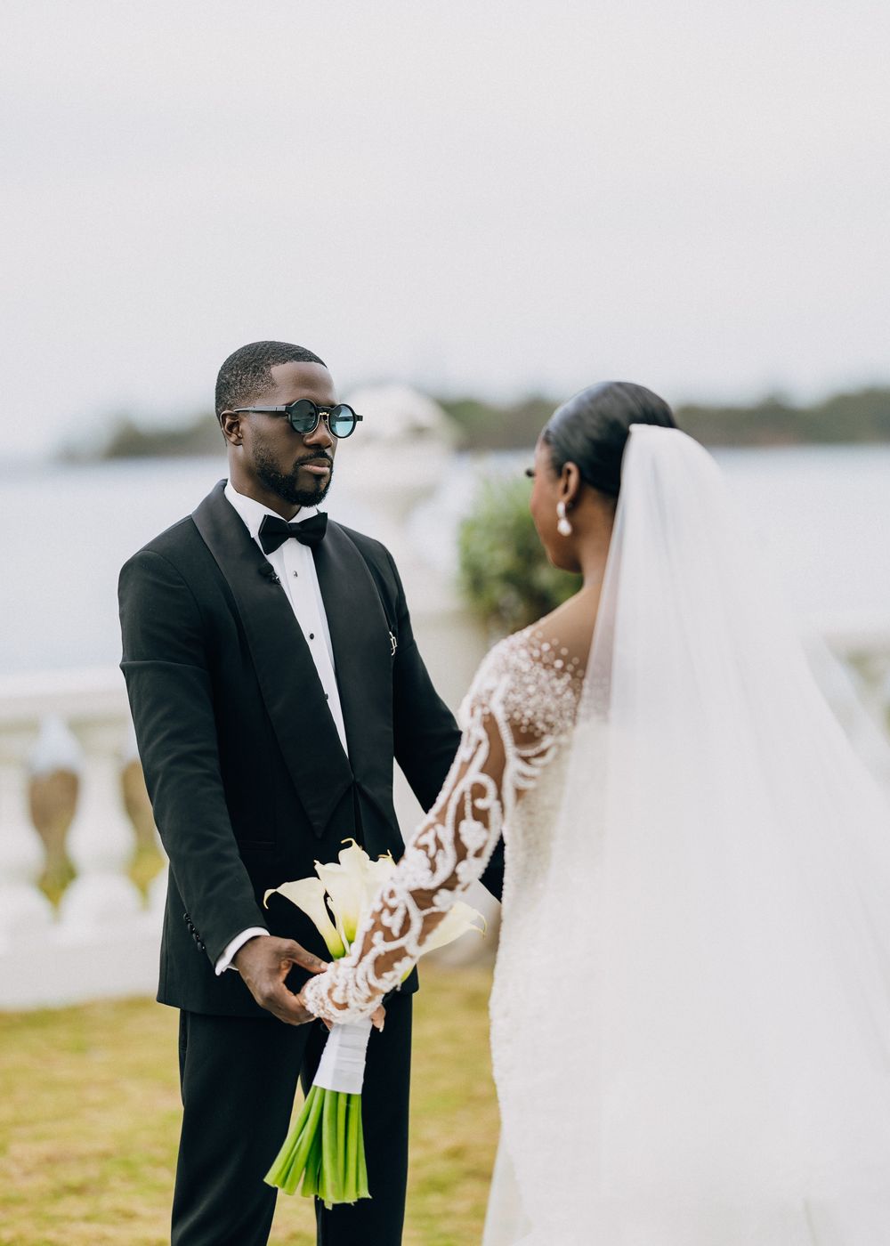 Bride and groom share an intimate moment during their first look at an outdoor waterfront wedding ceremony.