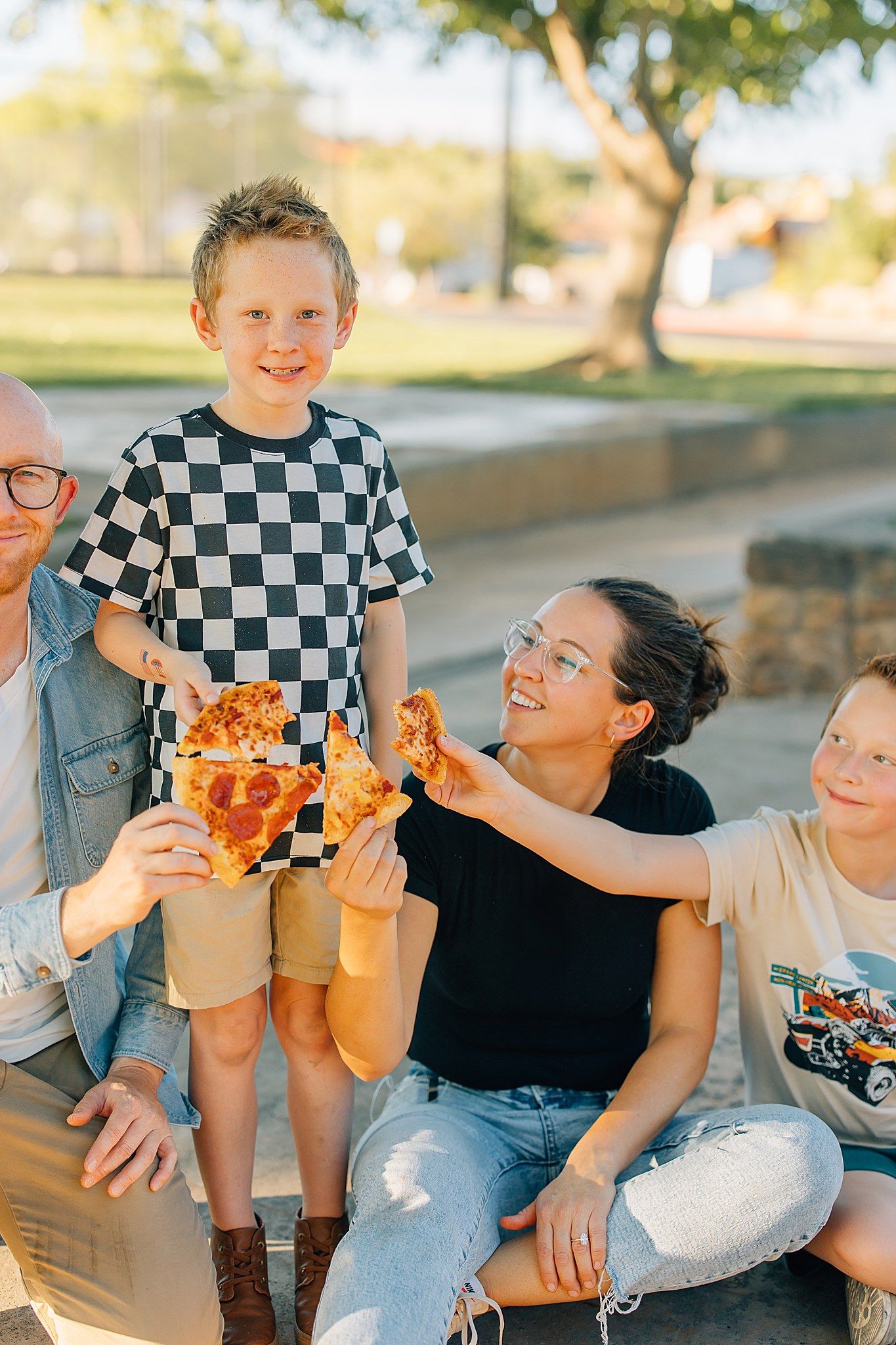 Family eating pizza smiling with each other.