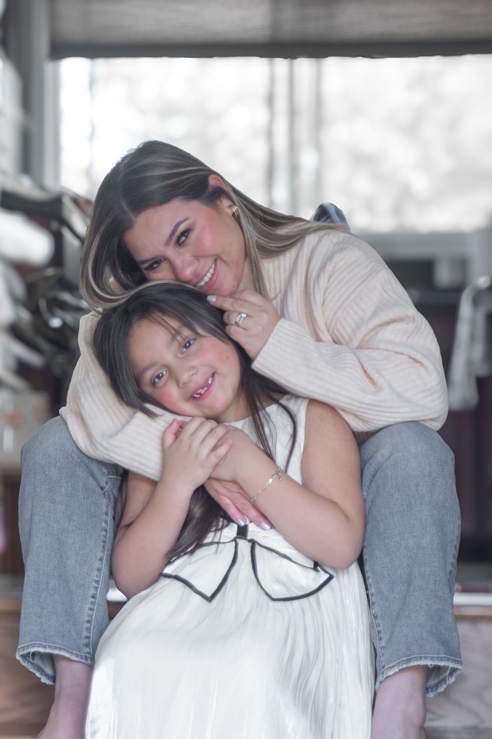 Four candid photos showing two people in casual clothing sitting together and sharing playful moments indoors.