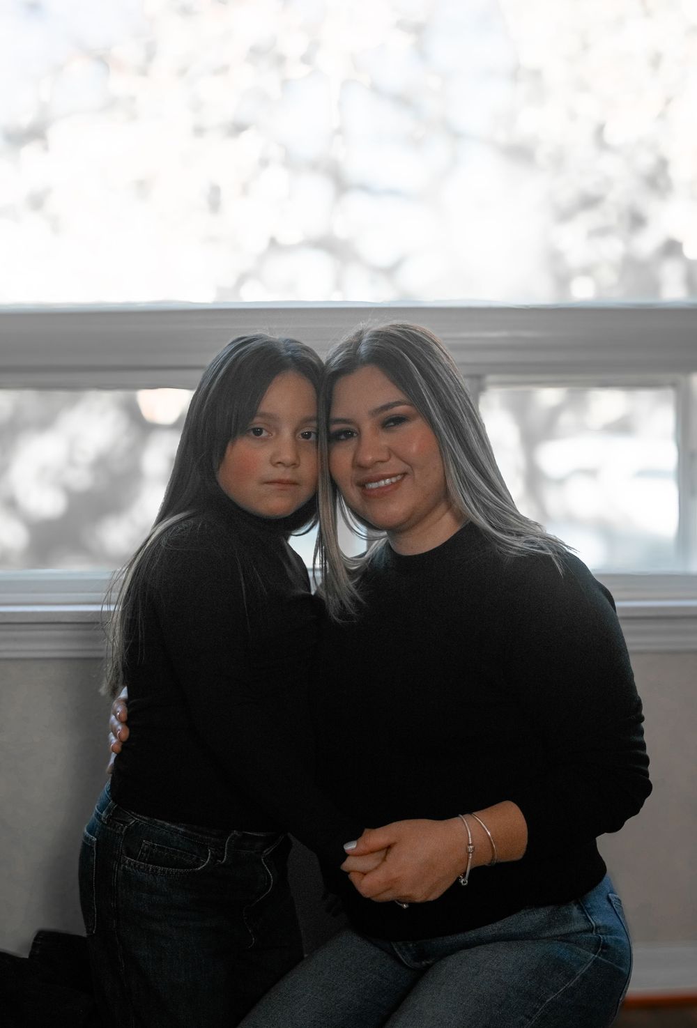 Two people wearing black tops sit close together in an intimate series of candid photos showing their connection.
