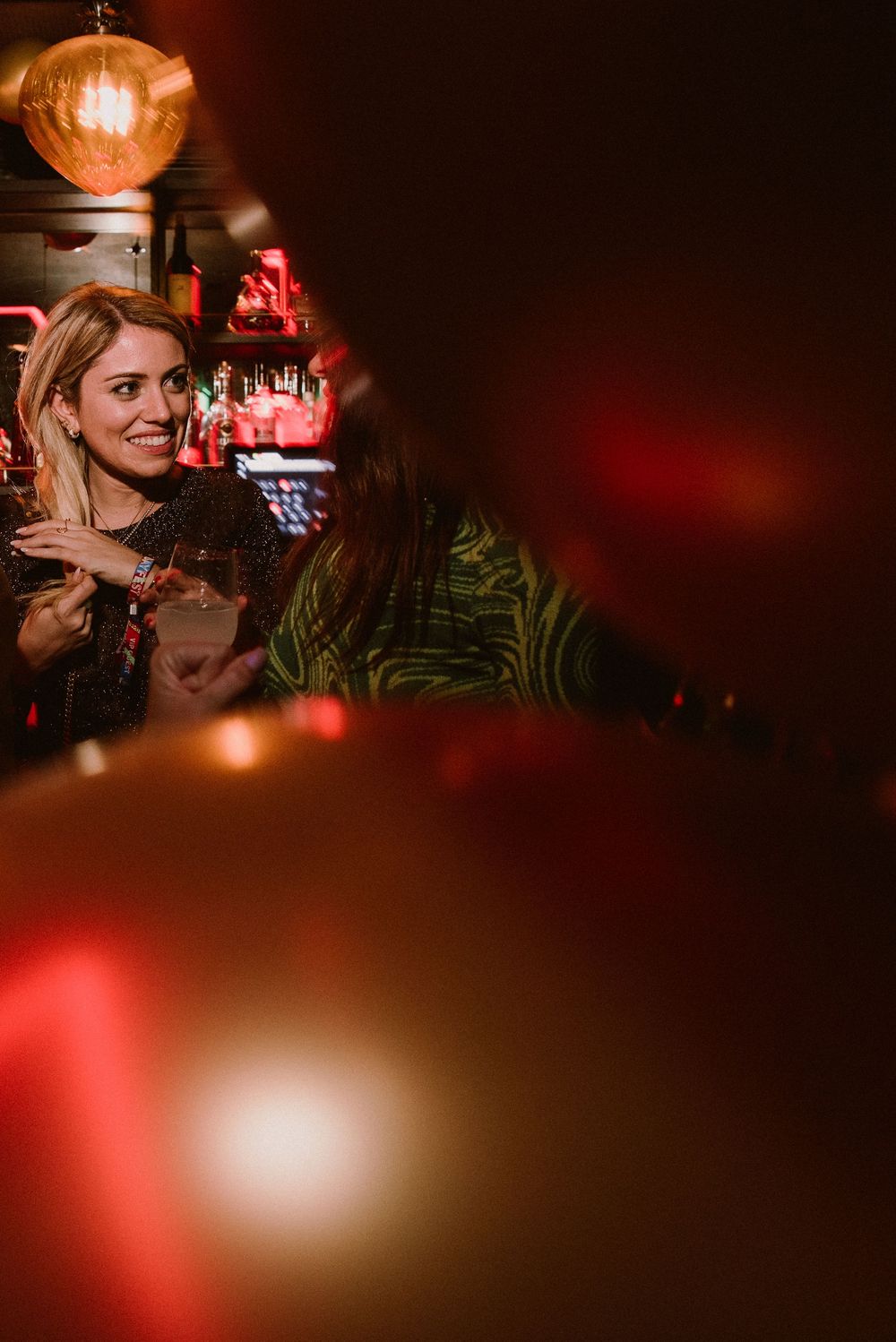 Atmospheric nightclub scene with warm lighting and red ambient glow creating a moody evening ambiance.