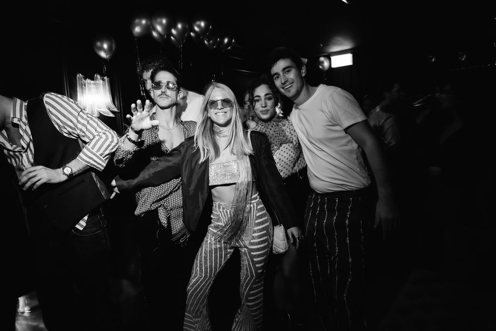 A group of people in black and white striped shirts performing together on stage during a theatrical production.