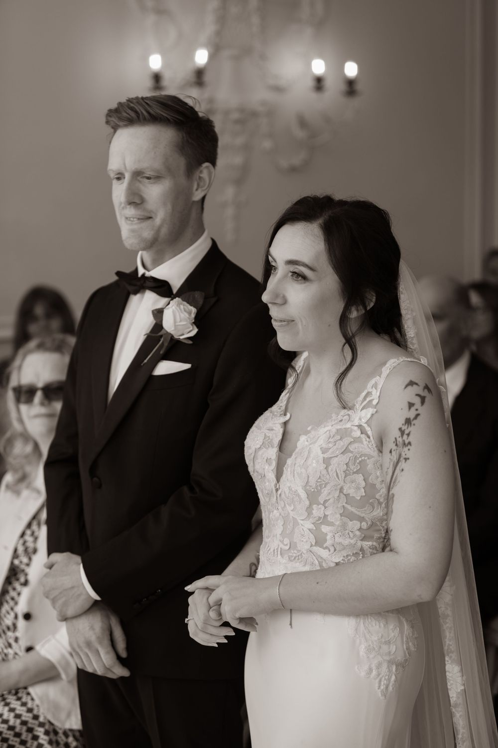 Black and white photo of bride and groom standing at altar during wedding ceremony.