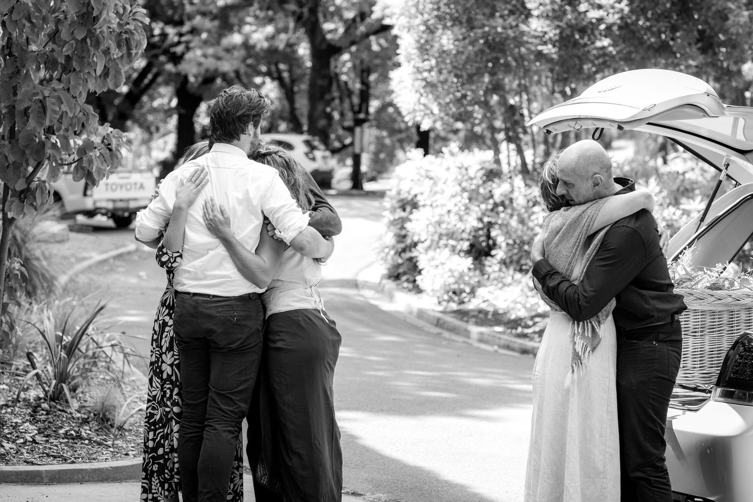 A series of black and white wedding photographs showing intimate moments between a couple in an outdoor garden setting.