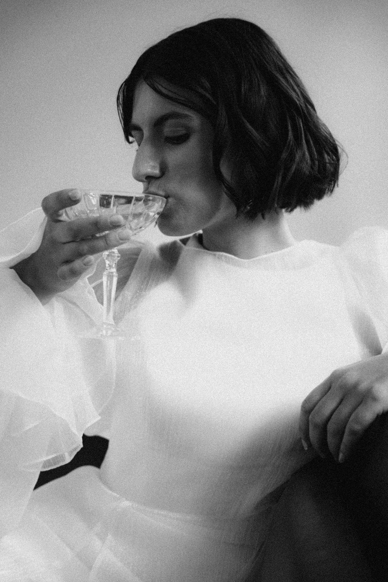 Black and white sequence of someone drinking from a glass in an artistic style.