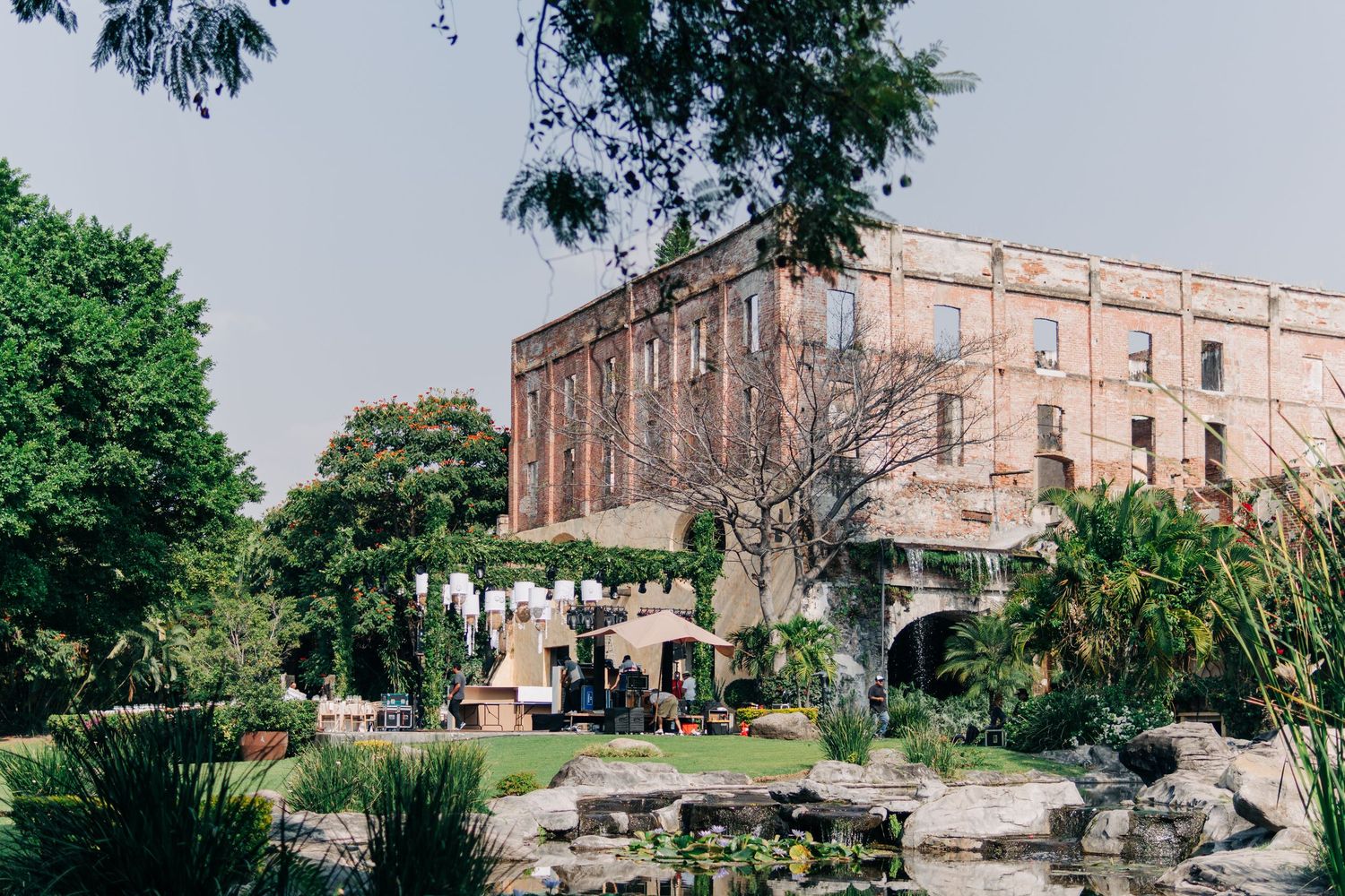 Historic stone building with outdoor garden seating area surrounded by lush greenery and landscaping.