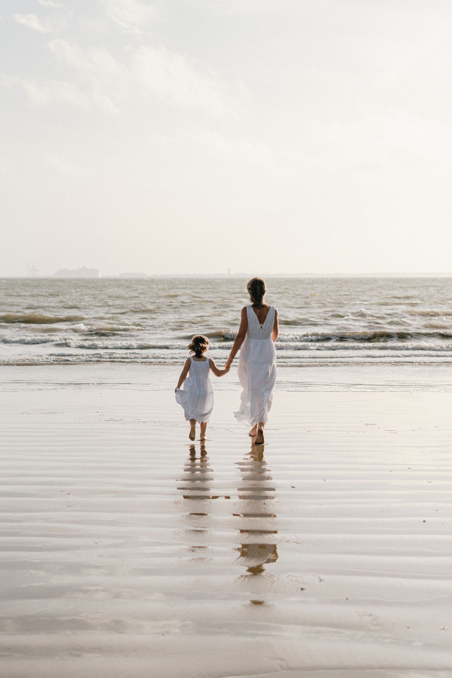 Mère et fille face à la mer, toutes petites dans cette immensité.