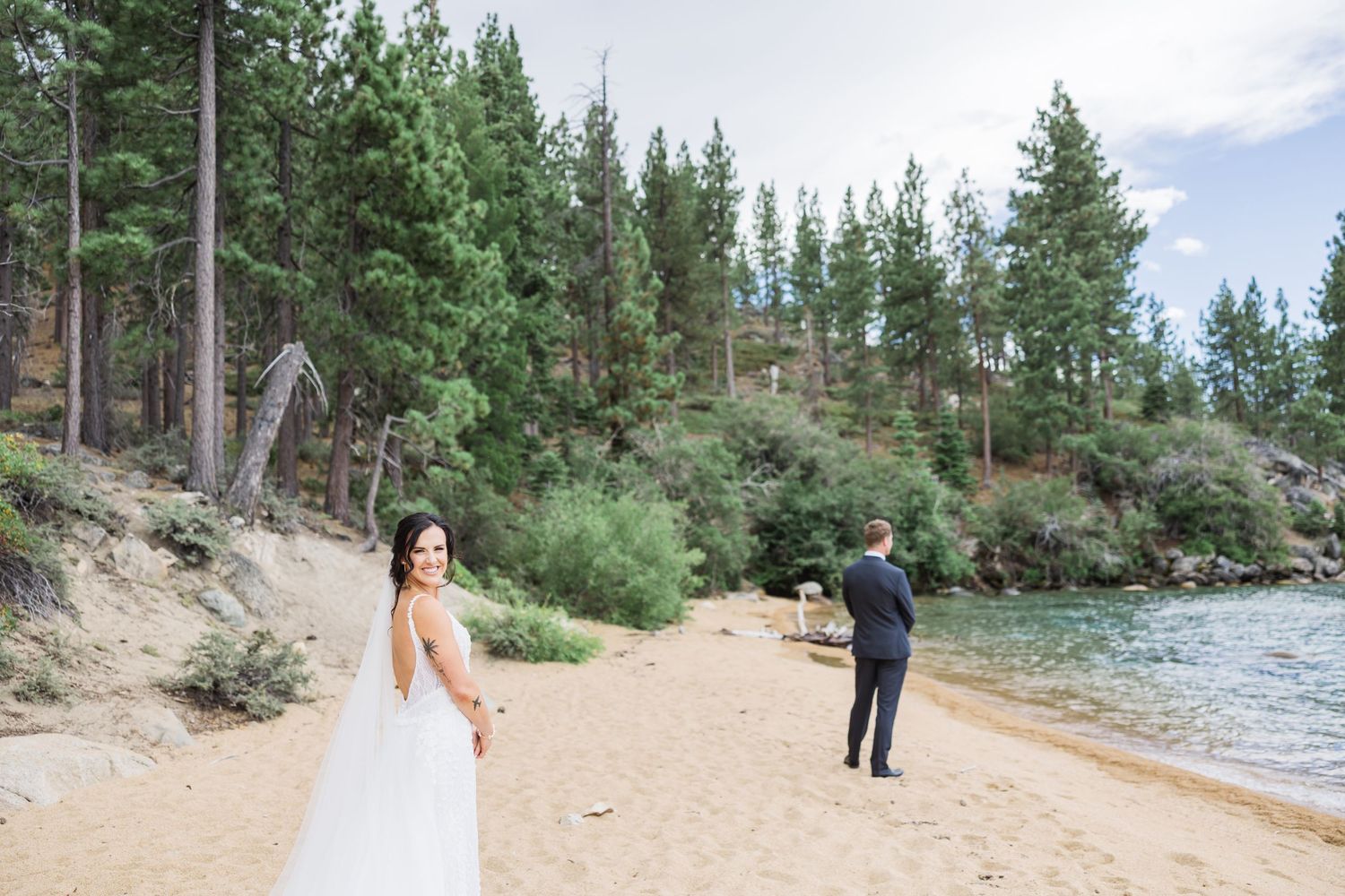 Wedding party shares joyful laughter together outdoors during formal portraits in a garden setting.